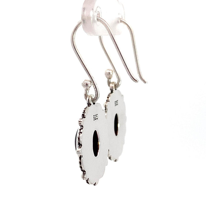photo of a pair of oval silver filigree earrings set with an oval red garnet on a white background side rear view