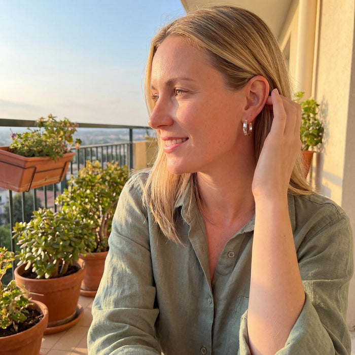 blonde model wearing Taxco sterling silver concave hammered hoop earrings with textured artisan finish and post clutch backing