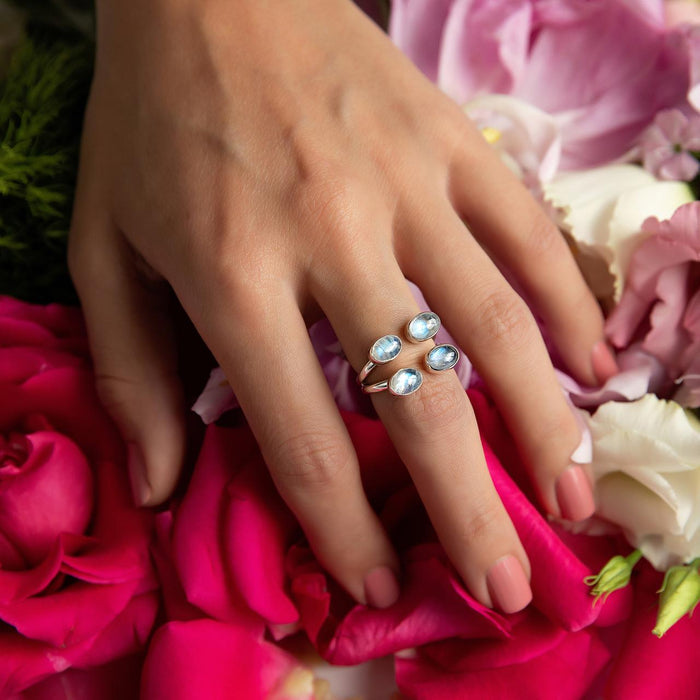 Sterling Silver Ring- Artisan Quad Bezel Moonstone Negative Space Ring on hand with flower background