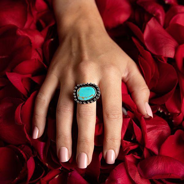 Sterling Silver Turquoise Ring- Manuel Figueroa's Turquoise Ring on models hand on red flower background