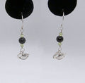 Pair of earrings with black and green beads and silver Swan charms on a white background.