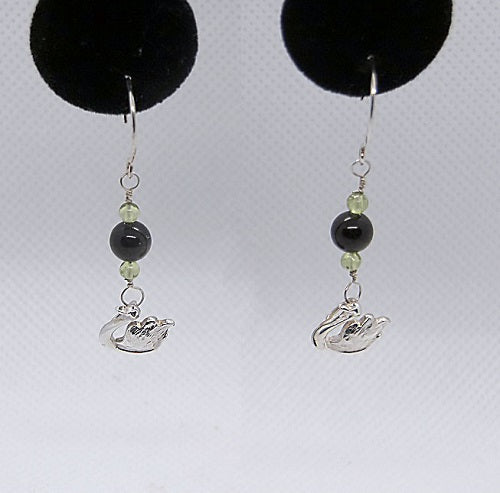 Pair of earrings with black and green beads and silver Swan charms on a white background.