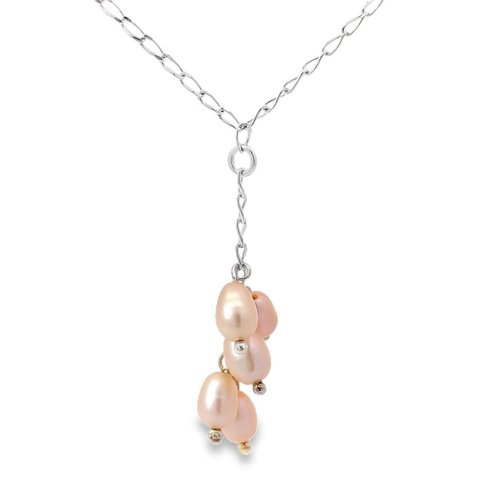 Photo of a cluster of peach colored pearls on a y shaped silver chain on a white background
