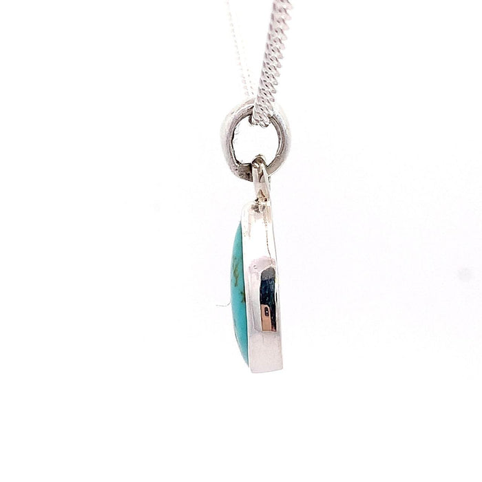 photo of a silver pear shape bezel set turquoise pendant and chain on a white background side view