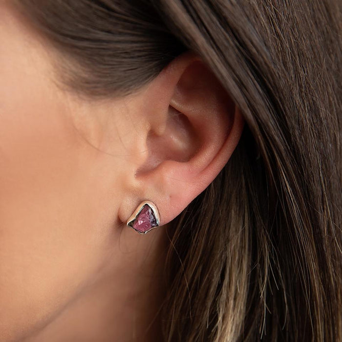 photo of a brunette model wearing Taxco artisan sterling silver rough ruby stud earrings with natural raw ruby gemstones handcrafted Mexican jewelry