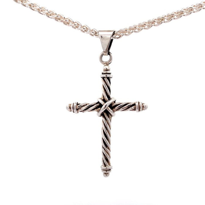 Photo of a silver twisted wire cross pendant on chain on a white background