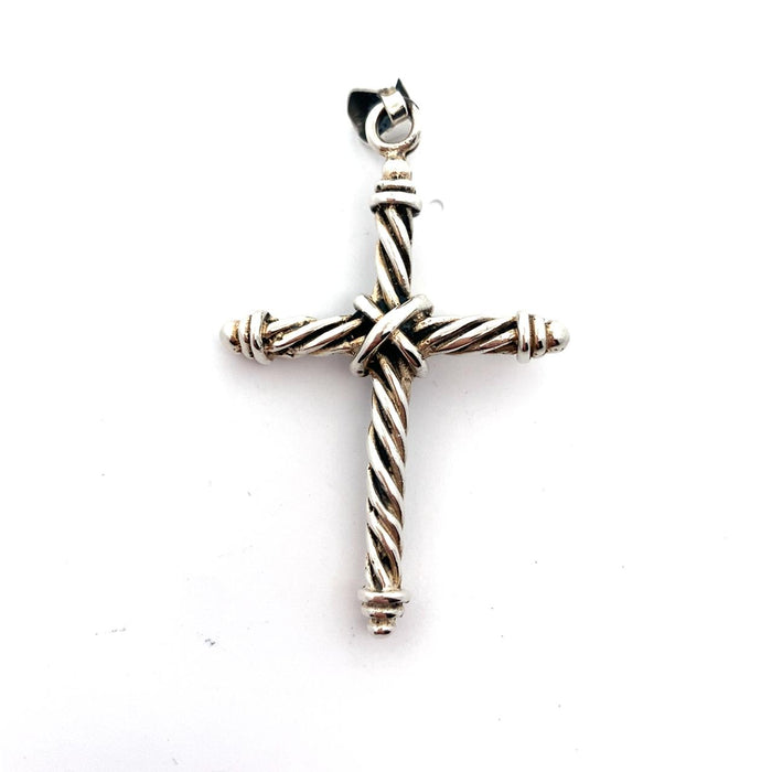 Photo of a silver twisted wire cross pendant on chain on a white background