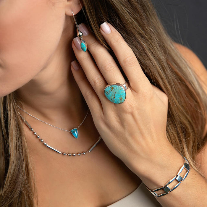 photo of a brunette model wearing silver and turquoise jewelry