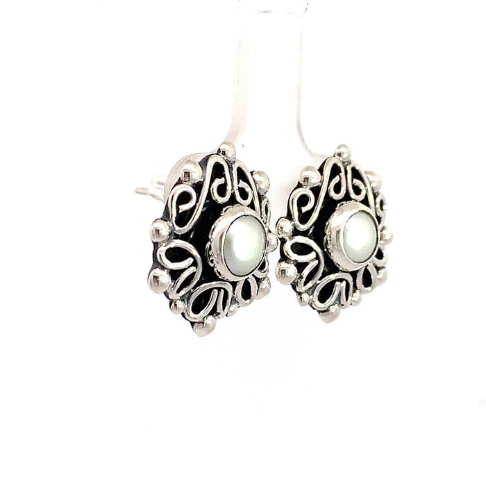 Taxco artisan sterling silver pearl stud earrings bezel set pearl with raised scrollwork frame handcrafted Mexican silver jewelry