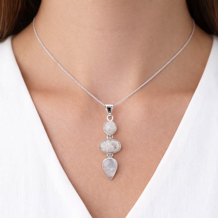 photo of a model wearing a Taxco artisan sterling silver triple moonstone pendant with round oval and pear cabochons bezel set 56mm long