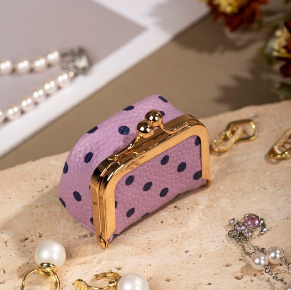 Cute, compact, and full of playful charm, the Tiny Treasure Kisslock Box is designed to keep small jewelry pieces beautifully tucked away. Featuring a soft textured exterior, charming polka-dot pattern, and a classic gold-tone kisslock closure, it looks like a miniature vintage purse while working as a sweet little jewelry storage box.