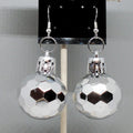 Silver faceted ball earrings on a gray background