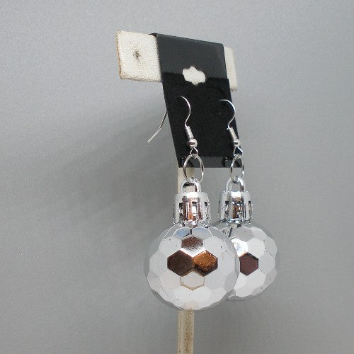 Pair of silver faceted ball earrings on a gray background