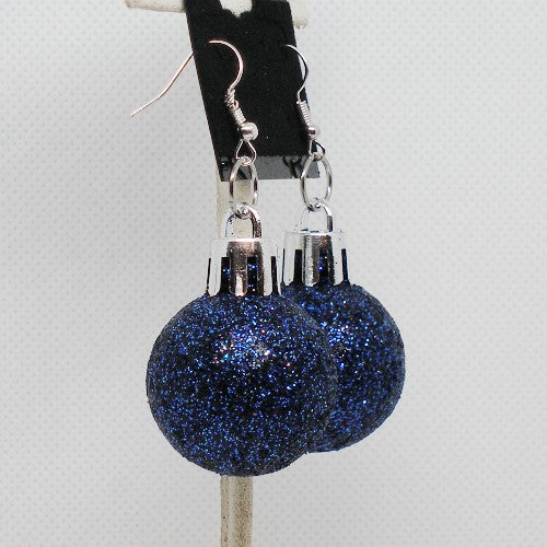 Blue glittery ball earrings on a gray background