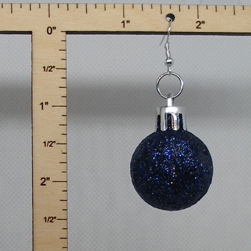 Blue glittery ball earring with silver hook on a ruler for scale