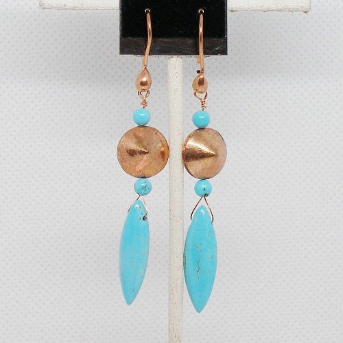 Pair of earrings with turquoise and copper beads and turquoise drop on a gray background