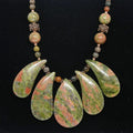 Necklace with green and brown teardrop-shaped beads on a black background
