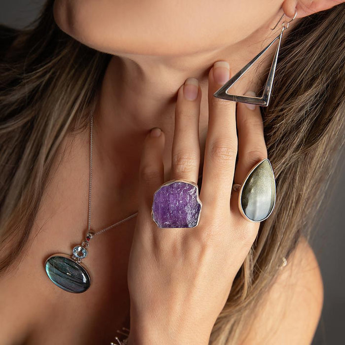 photo of a brunette model wearing a large pear shape obsidian sterling silver ring with other jewelry