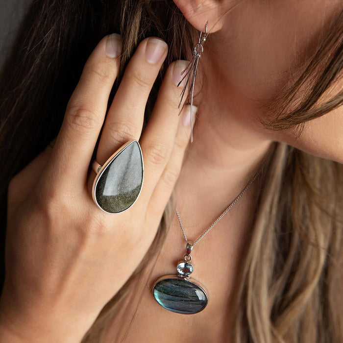 photo of a brunette model wearing a large pear shaped obsidian ring and other jewelry