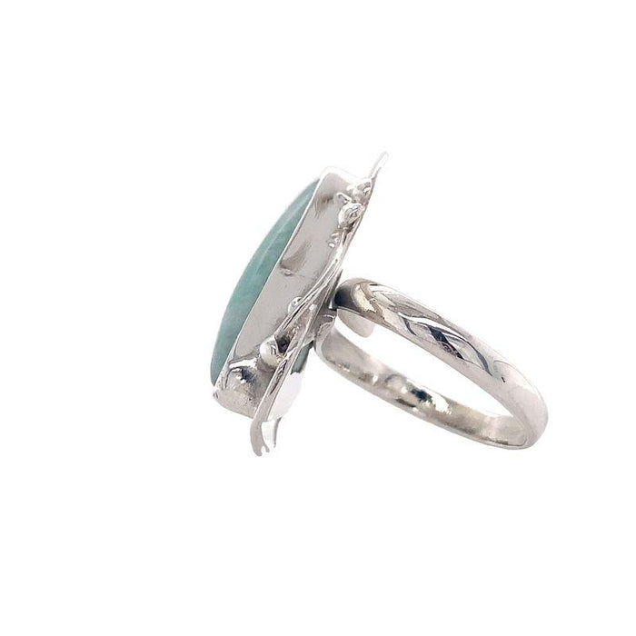 photo of a silver ring set with a triangular light blue opaque gem on a white background side view