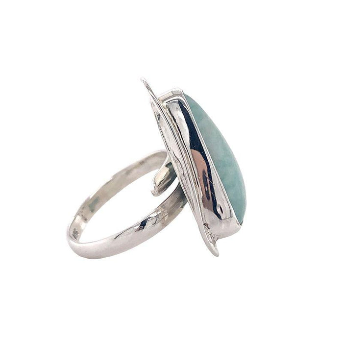 photo of a silver ring set with a triangular light blue opaque gem on a white background side view