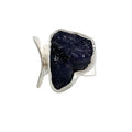 photo of a bold silver ring set with a raw irregularly shaped tanzanite on a white background front view