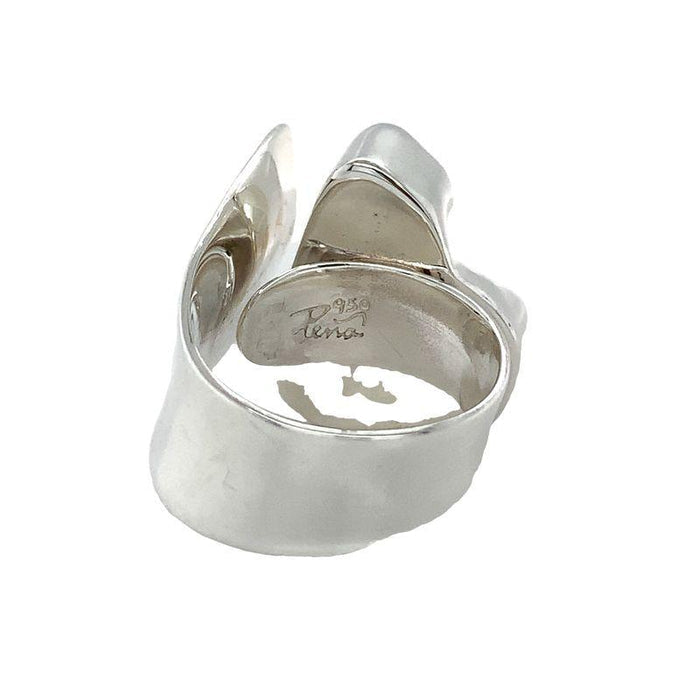 photo of a bold silver ring set with a raw irregularly shaped tanzanite on a white background rear view