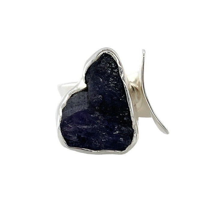 photo of a bold silver ring set with a raw irregularly shaped tanzanite on a white background front view