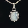 photo of a silver white moonstone pendant on a silver chain on a black background