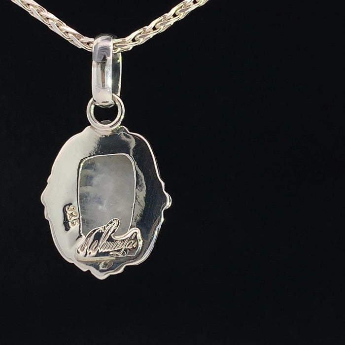 photo of a silver white moonstone pendant on a silver chain on a black background rear view
