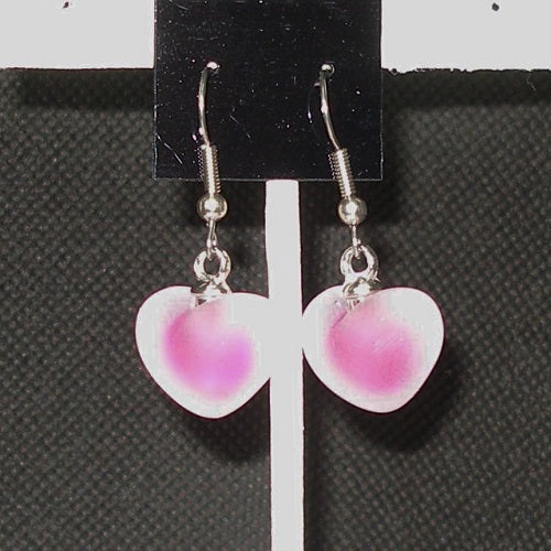 Heart-shaped earrings with pink and white design on a black card.