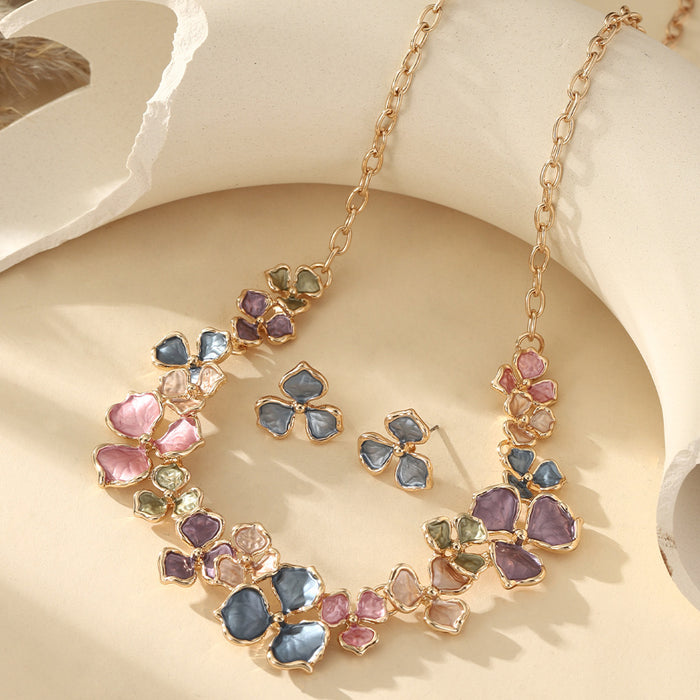 The Vivid Petale Set captures the poetry of spring through delicately shaped petals in soft pastel tones — lilac, rose, sky, and sage — all set in gleaming gold alloy. Designed to radiate joy and femininity, this floral necklace and earring duo adds a touch of artistry to every look, from brunches to weddings.