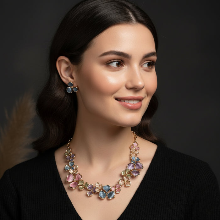 The Vivid Petale Set captures the poetry of spring through delicately shaped petals in soft pastel tones — lilac, rose, sky, and sage — all set in gleaming gold alloy. Designed to radiate joy and femininity, this floral necklace and earring duo adds a touch of artistry to every look, from brunches to weddings.