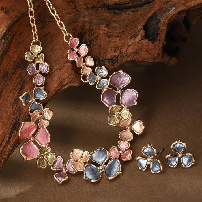 The Vivid Petale Set captures the poetry of spring through delicately shaped petals in soft pastel tones — lilac, rose, sky, and sage — all set in gleaming gold alloy. Designed to radiate joy and femininity, this floral necklace and earring duo adds a touch of artistry to every look, from brunches to weddings.