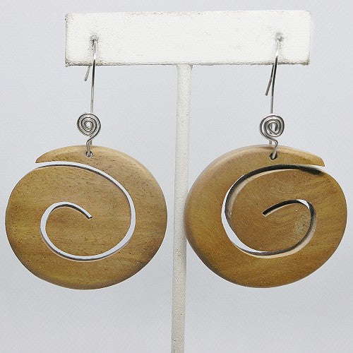 Wooden earrings with spiral design on a white stand against a light gray background